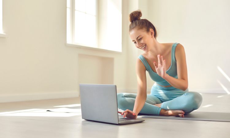 coach de fitness en ligne agitant devant son ordinateur