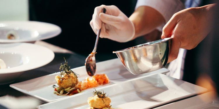 chef arrangeant la nourriture sur des assiettes