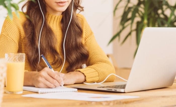 wanita yang duduk di meja mengikuti kursus online