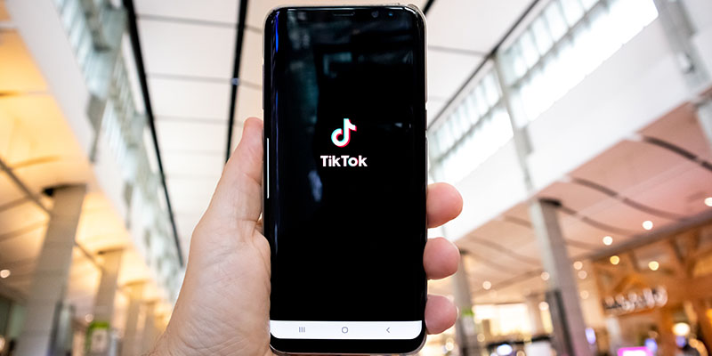 Ręka pokazująca telefon z aplikacją TikTok