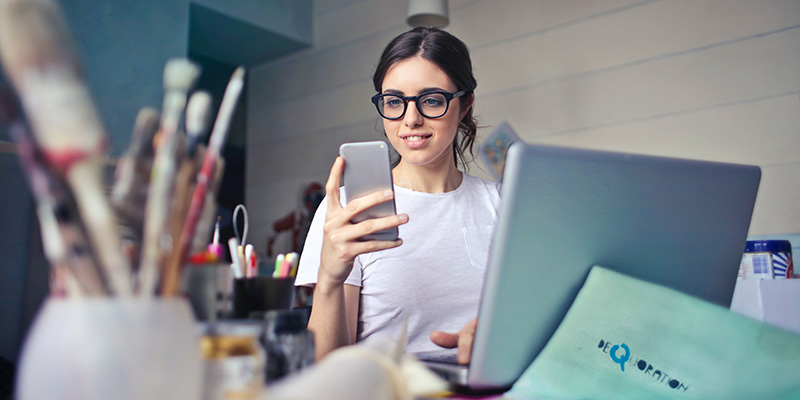 Seorang wanita muda berspesifikasi sedang menggulir telepon