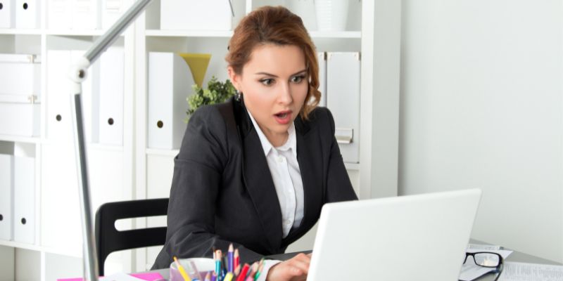 femme devant un ordinateur portable avec un regard surpris