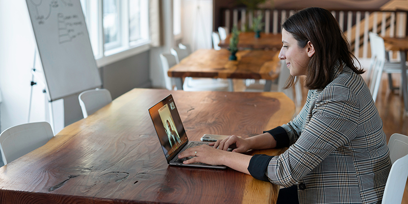 Uma jovem participando de uma videochamada em seu laptop