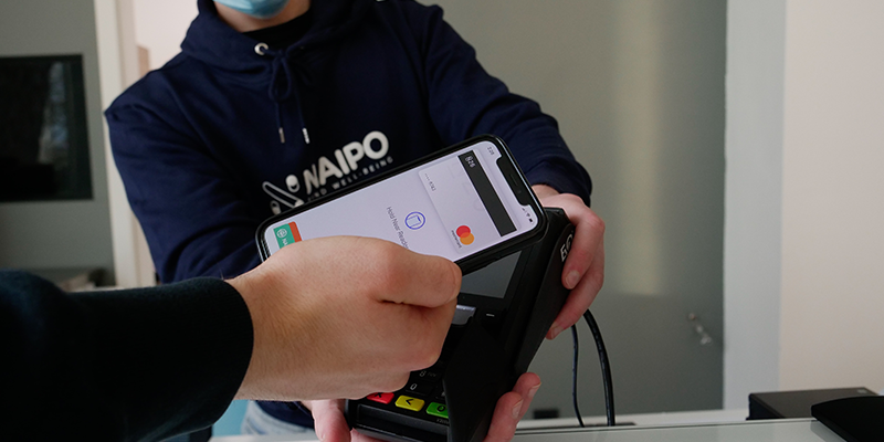 Un homme glissant sa carte sur une machine POS
