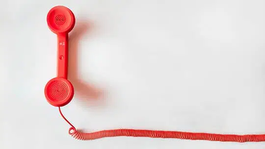 Ein rotes Telefon auf weißem Hintergrund.