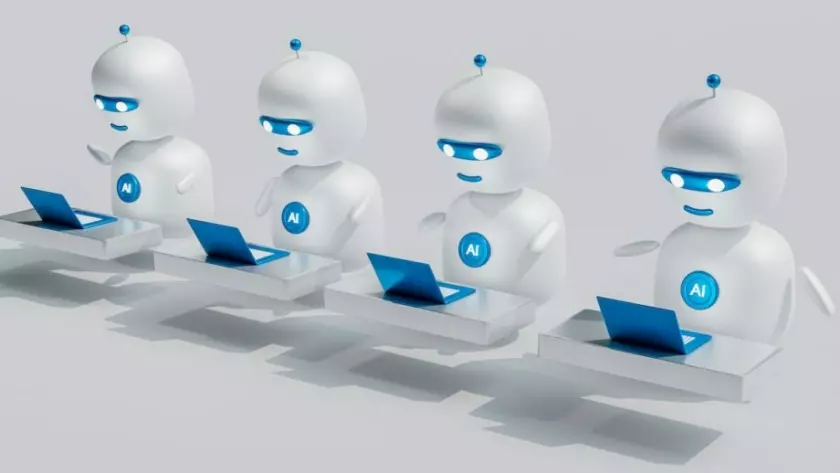 Grupa robotów z laptopami przed nimi.