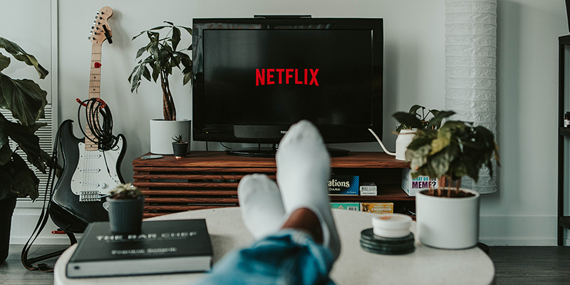 Seorang pria menonton Netflix di ruang tamunya