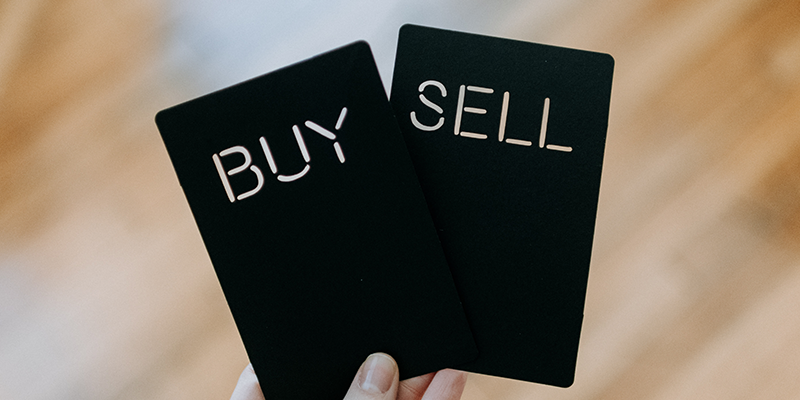 Dos tarjetas negras que dicen comprar y vender.